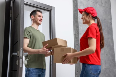 Courier giving parcels to man at house entrance