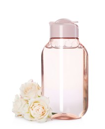 Bottle of micellar cleansing water and flowers on white background
