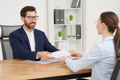 Photo of Businesspeople working with documents at table in office