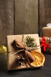 Photo of Beautiful gift box with Christmas decorations on black table