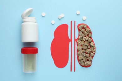 Paper cutout of kidneys with stones, pills and urine test on light blue background, flat lay