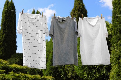 Washing line with clean clothes in garden. Drying laundry outside