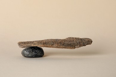Stone with tree branch on beige background. Harmony and balance concept