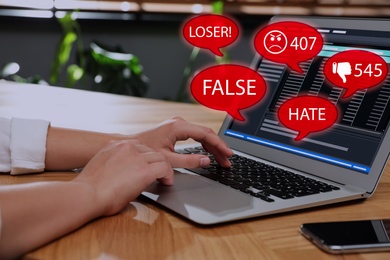 Image of Woman using laptop and icons with offensive messages, closeup. Cyber bulling concept