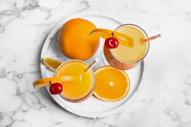 Fresh alcoholic Tequila Sunrise cocktails on marble table, top view
