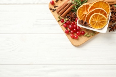Flat lay composition with mulled wine ingredients on white wooden table. Space for text