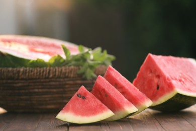 Slices of delicious ripe watermelon on wooden table outdoors