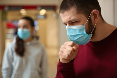Man wearing disposable mask indoors. Dangerous virus