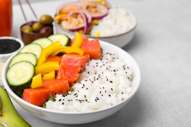 Photo of Poke bowls and ingredients on white table, closeup