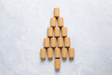 Photo of Christmas tree made of wine corks on light grey table, top view