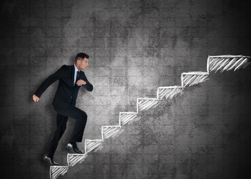 Image of Businessman walking up stairs drawing with chalk on dark background. Career ladder concept