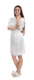 Young woman in silk robe on white background