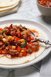 Tasty chili con carne with tortilla on white table