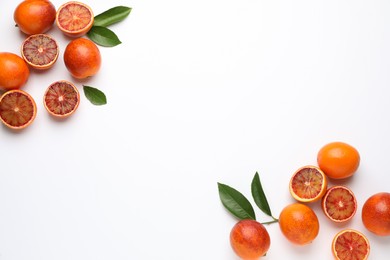 Many ripe sicilian oranges and leaves on white background, flat lay. Space for text