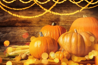 Composition with ripe pumpkins on wooden table, bokeh effect. Happy Thanksgiving day