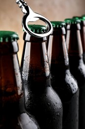 Photo of Opening bottle of beer on light brown background, closeup