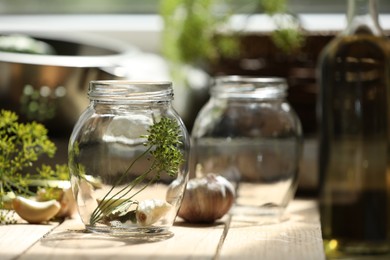 Empty glass jar and ingredients prepared for canning on wooden table. Space for text