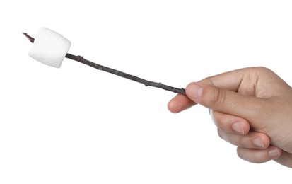 Woman holding twig with delicious puffy marshmallow on white background, closeup
