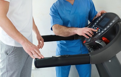 Patient exercising under physiotherapist supervision in rehabilitation center, closeup