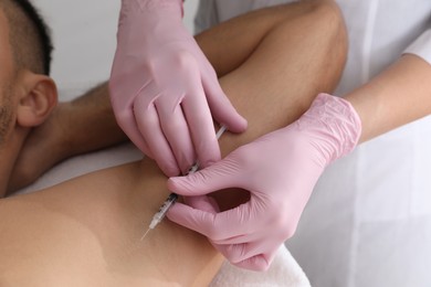 Cosmetologist injecting man's armpit, closeup. Treatment of hyperhidrosis