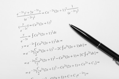 Sheet of paper with mathematical formulas and pen