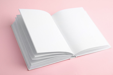 Open book with blank pages on pink background