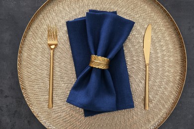 Tray with blue napkins, decorative ring and cutlery on grey table, top view