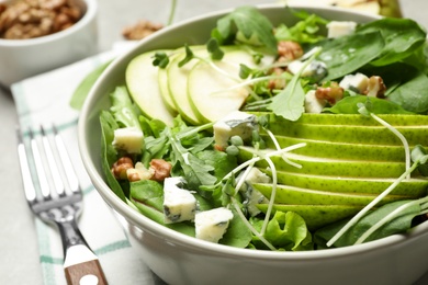 Tasty salad with pear slices in bowl, closeup