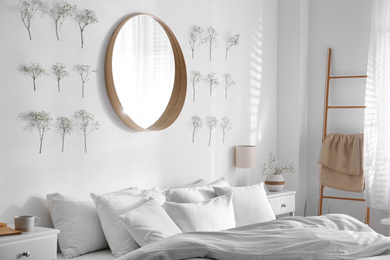 Modern bedroom interior with stylish round mirror