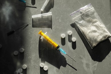Photo of Flat lay composition with different drugs and syringe on grey textured table