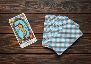 The World and other tarot cards on wooden table, flat lay