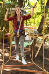 Teenage girl climbing in adventure park. Summer camp