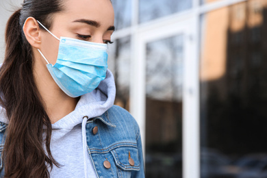Woman wearing disposable mask outdoors. Dangerous virus