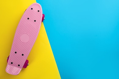Pink skateboard on color background, top view. Space for text