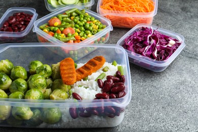 Set of plastic containers with fresh food on grey   table