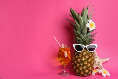 Photo of Funny pineapple with cocktail, plumeria flowers and starfish on pink background, space for text. Creative concept