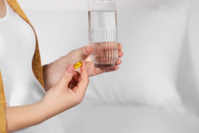 Pregnant woman taking pill on bed, closeup. Space for text