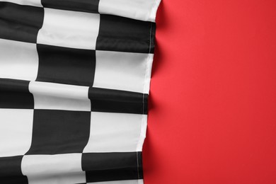Photo of Racing checkered flag on red background, top view. Space for text