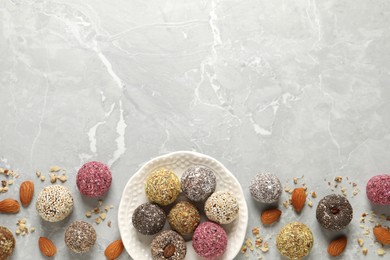 Delicious vegan candy balls and nuts on light grey marble table, flat lay. Space for text