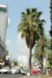 Photo of Blurred view of city street with palm trees and buildings