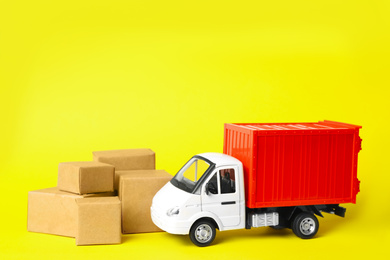 Toy truck with boxes on yellow background. Logistics and wholesale concept