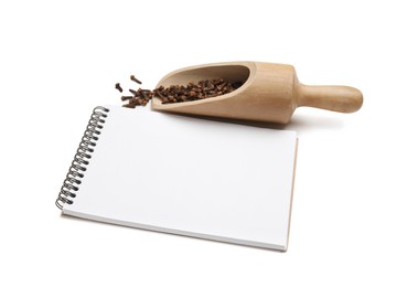 Blank recipe book, wooden scoop with cloves on white background. Space for text