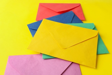 Colorful paper envelopes on yellow background. Mail service