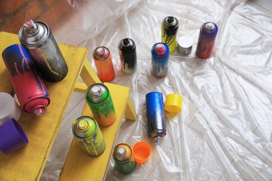 Used cans of spray paints indoors, above view. Graffiti supplies
