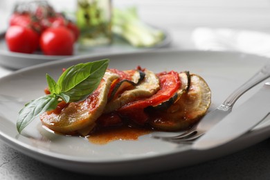 Photo of Delicious ratatouille served with basil on table, closeup