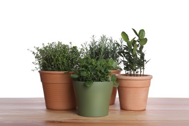 Pots with thyme, bay, mint and rosemary on wooden table against white background