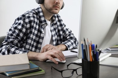 Young man using modern computer for studying at home, closeup. Distance learning