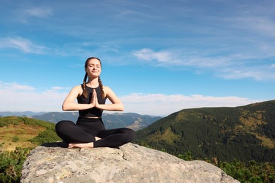Young woman practicing outdoor yoga in mountains, space for text. Fitness lifestyle