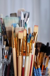 Closeup view of many different paintbrushes indoors
