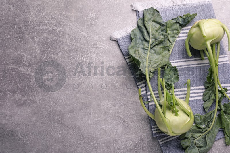 Whole ripe kohlrabi plants on grey table, flat lay. Space for text